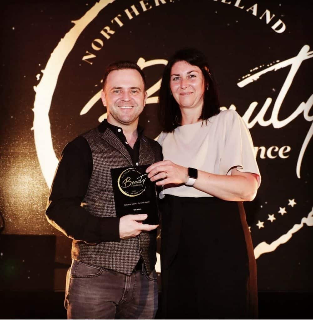 Scalp micropigmentation practitioner receiving an award at an industry event