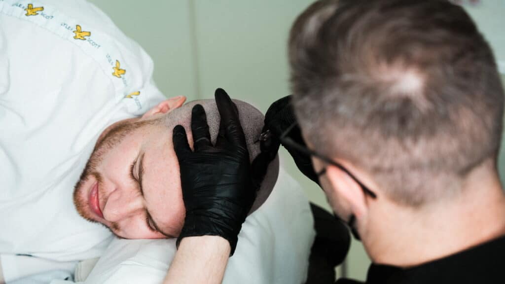 Scalp micropigmentation treatment being carried out by a practitioner during a session